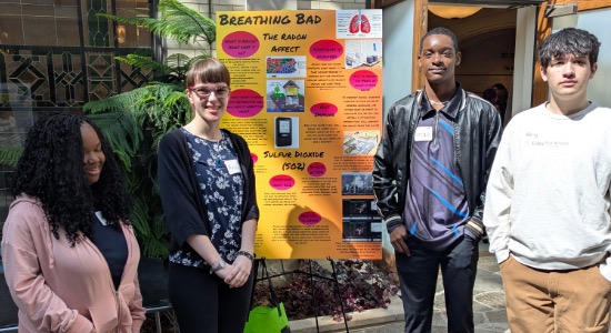 4 students around poster entitled Breathing Bad that presents their informational findings 